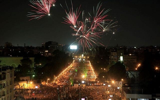 Fireworks light the sky as opponents of Egypt's Islamist President Mohammed Morsi protest outside the presidential palace in Cairo, Egypt, Monday, July 1 (photo credit: AP/Khalil Hamra)