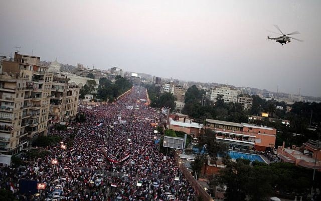 A military helicopter flies over the presidential palace as opponents of Egypt's Islamist President Mohammed Morsi celebrate, in Cairo, Egypt, Wednesday, July 3. (photo credit: AP/Khalil Hamra) A military helicopter flies over the presidential palace as opponents of Egypt's Islamist President Mohammed Morsi celebrate, in Cairo, Egypt, Wednesday, July 3. (photo credit: AP/Khalil Hamra)