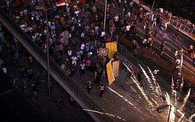 Supporters and opponents of Egypt's ousted Islamist President Mohammed Morsi clash on the 6 October bridge, near Maspero, where Egypt's state TV and radio station is located, in Cairo, Egypt, Friday, July 5, 2013. (Photo credit: AP/Khalil Hamra)