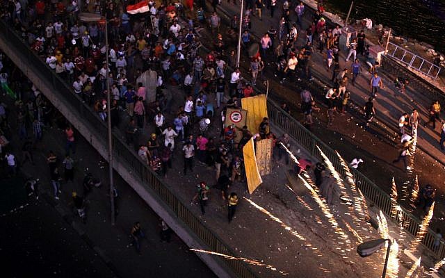 Supporters and opponents of Egypt's ousted Islamist President Mohammed Morsi clash on the 6 October bridge, near Maspero, where Egypt's state TV and radio station is located, in Cairo, Egypt, Friday, July 5, 2013. (Photo credit: AP/Khalil Hamra) Supporters and opponents of Egypt's ousted Islamist President Mohammed Morsi clash on the 6 October bridge, near Maspero, where Egypt's state TV and radio station is located, in Cairo, Egypt, Friday, July 5, 2013. (Photo credit: AP/Khalil Hamra)