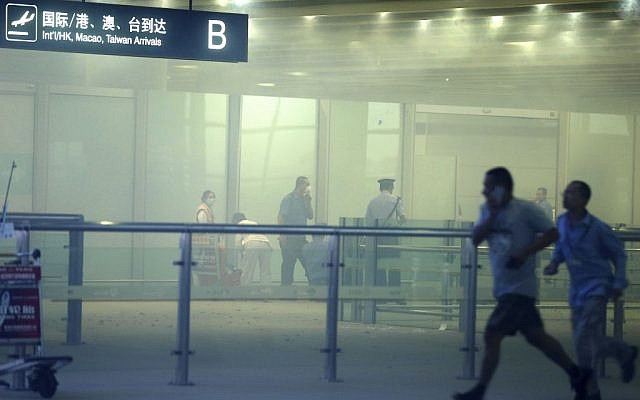 Medical workers and policemen work at the smoke-filled terminal 3 of the Beijing International Airport in Beijing, Saturday, July 20 (photo credit: AP/Xinhua, Chen Jianli) Medical workers and policemen work at the smoke-filled terminal 3 of the Beijing International Airport in Beijing, Saturday, July 20 (photo credit: AP/Xinhua, Chen Jianli)