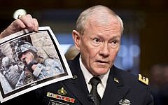 General Martin Dempsey, chairman of the Joint Chiefs of Staff, holds up a photo of a deployed American soldier as he testifies before the Senate Armed Services Committee at his reappointment hearing, on Capitol Hill in Washington, on Thursday, July 18, 2013. (photo credit: AP Photo/J. Scott Applewhite)