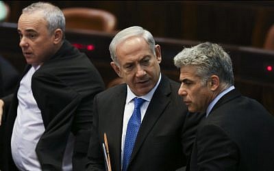 Prime Minister Benjamin Netanyahu seen speaking with Finance Minister Yair Lapid, with Intelligence Minister Yuval Steinitz in the background, in the Knesset, July 08, 2013. (photo credit: Yonatan Sindel/FLASH90)