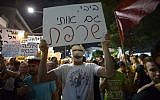 Protesters returned to Tel Aviv on Saturday night. This protester's sign reads 'Bibi, you have burned me too," a reference to budget cuts and Moshe Silman, who self-immolated one year ago. (photo credit: Gili Yaari/ Flash90)