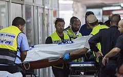 Rescue service members removing the bodies of one of the victims of the shooting Tuesday morning. (photo credit: Yonatan Sindel/Flash90)