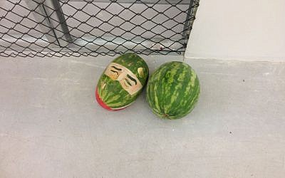 Fine arts student Iftach Ayali paints faces on watermelon in his work "Yes" (photo credit: Nicole Levin/Times of Israel)