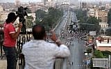 Journalists film an Egyptian military attack helicopter flying by the Presidential palace, in Cairo, Egypt on Friday, July 5 (photo credit: AP/Hassan Ammar)