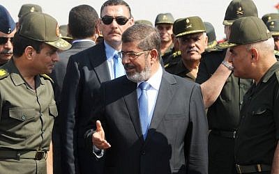 Egyptian President Mohammed Morsi, center, speaks with Minister of Defense, Lt. Gen. Abdel-Fattah el-Sissi, left, at a military base in Ismailia, Egypt, in October 2012 (photo credit: AP/Egyptian Presidency)