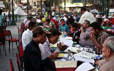 Egyptians break their fast the first day of Ramadan in Tahrir Square in Cairo, Egypt, on Wednesday, July 10, 2013. (photo credit: AP Photo/Nasser Shiyoukhi)