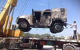 Illustrative: The charred remains of an armored vehicle are loaded onto a truck after a rocket-propelled grenade attack on a police checkpoint in el-Arish, Egypt, Friday, July 12, 2013. (photo credit: AP/Muhammed Sabry)