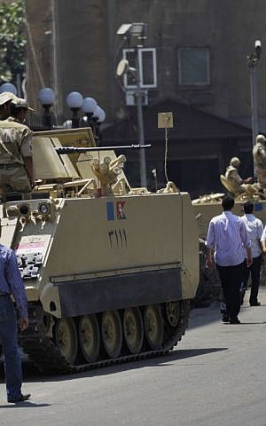 Egyptian military soldiers stand guard atop armored personnel carriers at Maspero, an Egypt's state tv and radio station, not far from Tahrir Square in Cairo Saturday, July 6, 2013. (AP Photo/Hiro Komae)