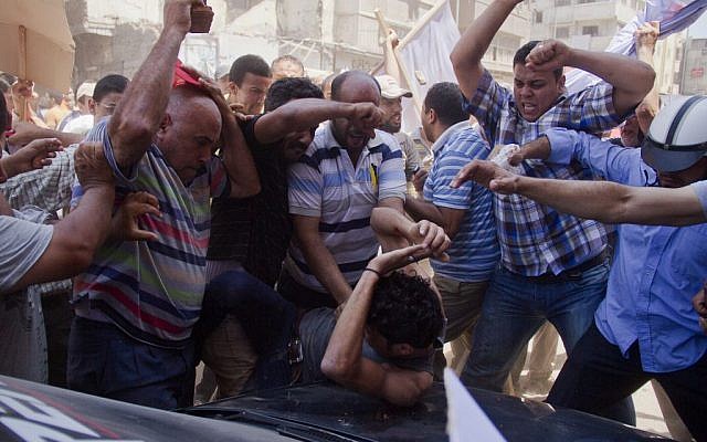 An Egyptian opposition protester is beaten by supporters of Egyptian president Mohammed Morsi, as a main raises a brick overhead, in downtown Damietta, Egypt, Wednesday, July 3, 2013. (photo credit: AP Photo/Hamada Elrasam) An Egyptian opposition protester is beaten by supporters of Egyptian president Mohammed Morsi, as a main raises a brick overhead, in downtown Damietta, Egypt, Wednesday, July 3, 2013. (photo credit: AP Photo/Hamada Elrasam)