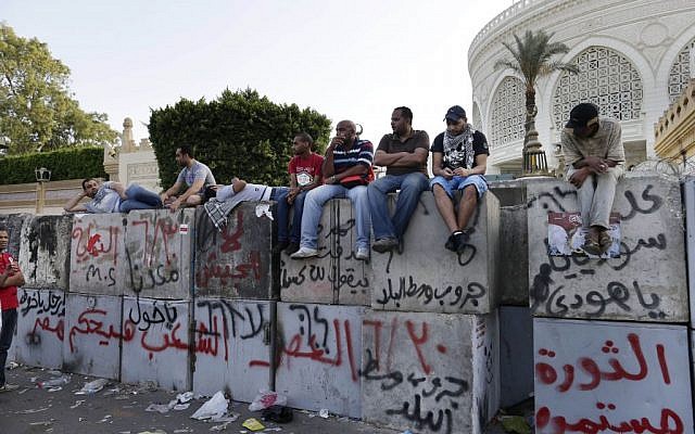 Opponents of Egypt's Islamist President Mohammed Morsi protest outside the presidential palace in Cairo, Egypt, on Monday, July 1, 2013. Arabic reads: "Revolution continues, June 30, victory." (photo credit: AP Photo/Hassan Ammar)