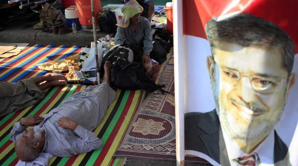 Supporters of ousted president Mohammed Morsi rest at their encampment in Nasr City in Cairo, Egypt on Thursday. Residents of the area have complained about protesters blocking the roads and using nearby gardens for washing and sewage purposes. (photo credit: AP Photo/Khalil Hamra)