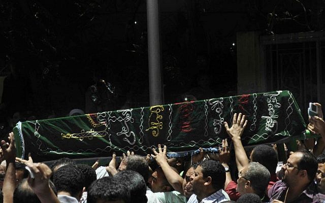 Mourners carry the coffin of Mohamed Abdel Hamid Mecca Masjid, who was killed Sunday when gunmen on a motorcycle opened fire on a protests against Egypt's Islamist President, Mohammed Morsi, in Assiut, Egypt, Monday, July 1 (photo credit: AP/Mamdouh Thabet) Mourners carry the coffin of Mohamed Abdel Hamid Mecca Masjid, who was killed Sunday when gunmen on a motorcycle opened fire on a protests against Egypt's Islamist President, Mohammed Morsi, in Assiut, Egypt, Monday, July 1 (photo credit: AP/Mamdouh Thabet)