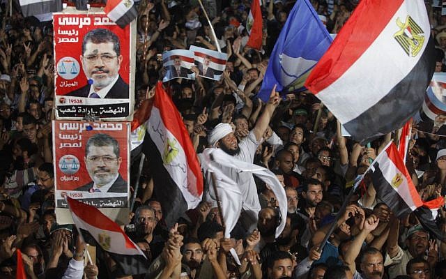 Supporters of Egypt's Islamist President Mohammed Morsi wave national flags and his posters during a rally in Nasser City, in Cairo, Egypt, on Monday, July 1, 2013. (photo credit: AP/Amr Nabil) Supporters of Egypt's Islamist President Mohammed Morsi wave national flags and his posters during a rally in Nasser City, in Cairo, Egypt, on Monday, July 1, 2013. (photo credit: AP/Amr Nabil)