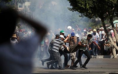 People carry the body of a man shot by Egyptian troops in Cairo, Egypt, Friday, July 5 (photo credit: AP/Khalil Hamra) People carry the body of a man shot by Egyptian troops in Cairo, Egypt, Friday, July 5 (photo credit: AP/Khalil Hamra)