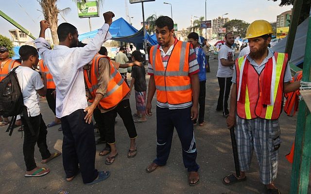 Supporters of Egypt's ousted President Mohammed Morsi check a man at a checkpoint where protesters have installed their camp at Nasr city in Cairo, Egypt, on Thursday, July 18, 2013. (photo credit: AP Photo/Hussein Malla) Supporters of Egypt's ousted President Mohammed Morsi check a man at a checkpoint where protesters have installed their camp at Nasr city in Cairo, Egypt, on Thursday, July 18, 2013. (photo credit: AP Photo/Hussein Malla)