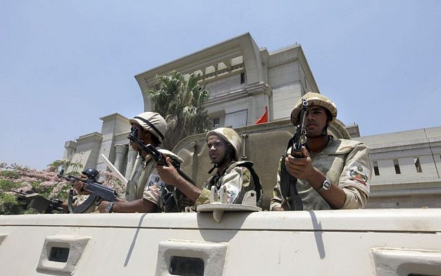 Egyptian army soldiers stand alert in front of the constitutional court where Egypt's chief justice Adly Mansour was sworn in as the interim president on July 4, 2013. (photo credit: Amr Nabil/AP) Egyptian army soldiers stand alert in front of the constitutional court where Egypt's chief justice Adly Mansour was sworn in as the interim president on July 4, 2013. (photo credit: Amr Nabil/AP)