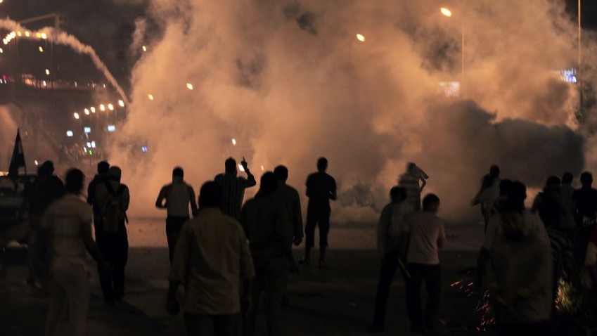 Supporters of Egypt's ousted president Mohammed Morsi clash with riot police at Nasr City, where protesters have installed their camp and hold their daily rally, in Cairo on Friday. (photo credit: AP Photo/Khalil Hamra) 