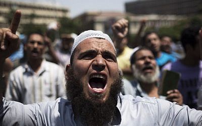 Supporters of Egypt's ousted president Mohammed Morsi chant slogans against the military near Cairo University in Giza, southwest of Cairo, Egypt, last month (photo credit: AP/Manu Brabo)