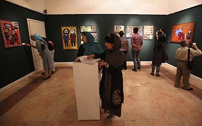 In this picture taken on Monday, July 1, 2013, Iranians visit an art gallery with paintings, in Tehran, Iran. (photo credit: AP/Vahid Salemi)