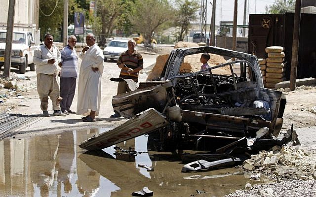 Civilians inspect the aftermath of a car bomb attack in Baghdad, Iraq, Wednesday, July 24, 2013 (photo credit: AP/Karim Kadim) Civilians inspect the aftermath of a car bomb attack in Baghdad, Iraq, Wednesday, July 24, 2013 (photo credit: AP/Karim Kadim)