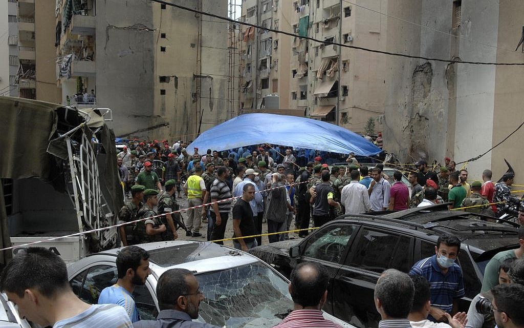Security forces and civilians stand at the scene of a bombing in the Beir el-Abed, a southern suburb of Beirut, Lebanon, Tuesday, July 9 (photo credit: AP/Ahmed Omar)