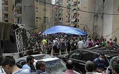 Security forces and civilians stand at the scene of a bombing in the Beir el-Abed, a southern suburb of Beirut, Lebanon, Tuesday, July 9 (photo credit: AP/Ahmed Omar)