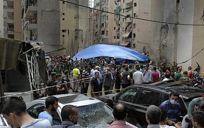 Security forces and civilians stand at the scene of a bombing in the Beir el-Abed, a southern suburb of Beirut, Lebanon, Tuesday, July 9 (photo credit: AP/Ahmed Omar)