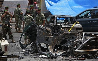 Security forces stand at the scene of a bombing in the Beir el-Abed, a southern suburb of Beirut, Lebanon, Tuesday, July 9 (photo credit: AP/Bilal Hussein)