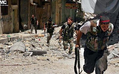 Syrian rebels run during heavy clashes with soldiers loyal to President Bashar Assad. (photo credit: AP/Aleppo Media Center AMC)