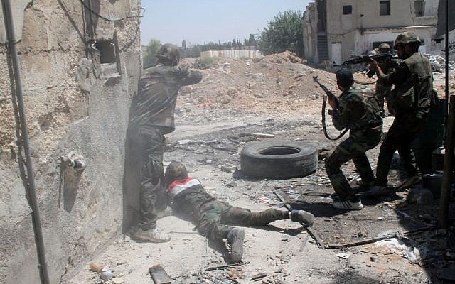 Syrian army personnel shoot toward rebel fighters during a tour for journalists organized by the Syrian Information Ministry in Damascus, Sunday, July 14, 2013. (photo credit: AP/Bassem Tellawi) Syrian army personnel shoot toward rebel fighters during a tour for journalists organized by the Syrian Information Ministry in Damascus, Sunday, July 14, 2013. (photo credit: AP/Bassem Tellawi)