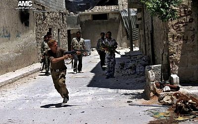 A Syrian rebel fires his weapon during heavy clashes with soldiers loyal to President Bashar Assad near Aleppo International Airport on July 2, 2013. (photo credit: AP/Aleppo Media Center AMC).