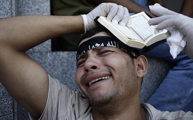 An Egyptian grieves for supporters of Egypt's ousted President Mohammed Morsi, who were killed in overnight clashes with security forces, at a field hospital in Nasr City, Cairo, July 27, 2013. (photo credit: AP Photo/Hassan Ammar) An Egyptian grieves for supporters of Egypt's ousted President Mohammed Morsi, who were killed in overnight clashes with security forces, at a field hospital in Nasr City, Cairo, July 27, 2013. (photo credit: AP Photo/Hassan Ammar)