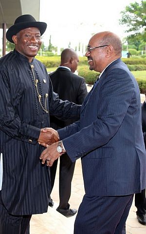 President of Nigeria Goodluck Jonathan, left, and Sudanese President Omar al-Bashir right, shake hands before an African Union summit on health in Abuja, Nigeria, on Monday, July 15, 2013. (photo credit: AP Photo/Sunday Aghaeze)