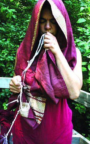 Taya Shere, a founder of Kohenet, the Hebrew Priestess Institute, kissing the fringes of her prayer shawl. (photo credit: Cathleen Maclearie/JTA) Taya Shere, a founder of Kohenet, the Hebrew Priestess Institute, kissing the fringes of her prayer shawl. (photo credit: Cathleen Maclearie/JTA)