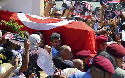 Tunisians carry the coffin of opposition politician Mohammed Brahmi out of his home in El Ghazela, in the suburb of Tunis, prior to his funeral in Tunis on Saturday. (photo credit: AP Photo/Hassene Dridi)