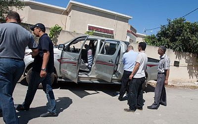Tunisian police officers inspect Mohammed Brahmi's car in which he was shot to death outside his home in Tunis, Tunisia, on Thursday, July 25, 2013. (photo credit: AP Photo/Amine Landoulsi)
