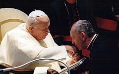 Jorge Mario Bergoglio, Archbishop of Buenos Aires, right, kisses the hand of Pope John Paul II during a ceremony at the Vatican. Bergoglio, who since then became Pope Francis, cleared Pope John Paul II for sainthood (photo credit: AP/Sergio Rubin)