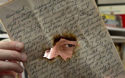 Historian Andrew Carroll poses for a photograph, in Washington, with one of his war letters that has a bullet hole in it. (photo credit: AP Photo/Alex Brandon)