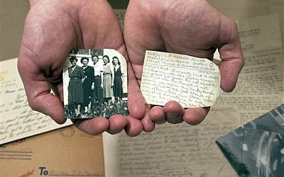 Historian Andrew Carroll poses for a photograph with one of his war letters that has been written on the back of photographs, in Washington. (photo credit: AP Photo/Alex Brandon)