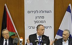 Palestinian politician and head of the Palestinian Legislative Council Abdallah Abdallah (left), Israeli parliament member Hilik Bar (center) and member of the Central Committee of Fatah Mohammad Madani seen in the Israeli parliament in Jerusalem, July 31, 2013, with the Palestinian and Israeli flags behind them (photo credit: Miriam Alster / Flash90)