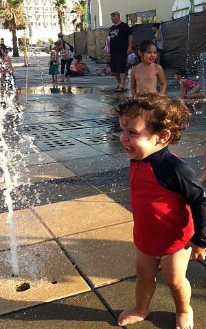 Delighting in the impromptu water playground at the Tel Aviv port (Courtesy Miriam Warshaviak)