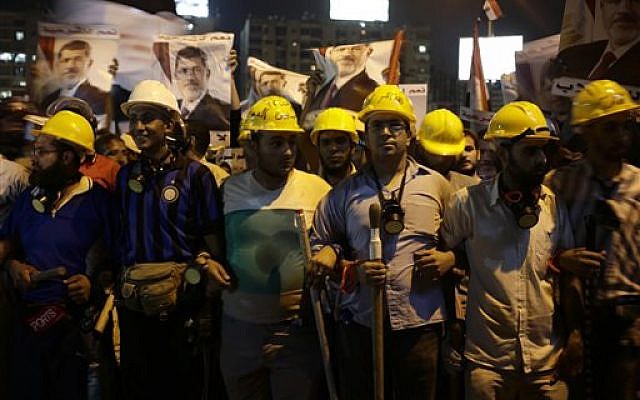 Supporters of Egypt's ousted President Mohammed Morsi hold sticks and wear protective gear during a march in Nasr City, where demonstrators have installed a camp and hold daily rallies, in Cairo, Egypt, late Tuesday, July 30, 2013 (photo credit: AP Photo/Hassan Ammar) Supporters of Egypt's ousted President Mohammed Morsi hold sticks and wear protective gear during a march in Nasr City, where demonstrators have installed a camp and hold daily rallies, in Cairo, Egypt, late Tuesday, July 30, 2013 (photo credit: AP Photo/Hassan Ammar)