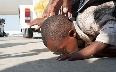 A child kisses the ground after arriving in Israel on Wednesday. (photo credit: Moshik Brin/Courtesy Jewish Agency)