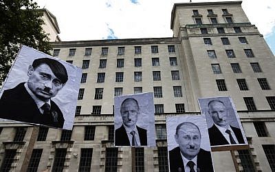 Protest signs displayed in London over the weekend liken Russian leader Vladimir Putin to Adolf Hitler. (AP Photo/Lefteris Pitarakis)
