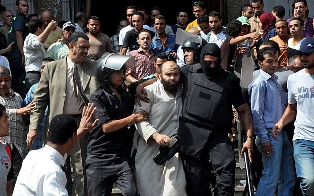 Egyptians security forces escort an Islamist supporter of the Muslim Brotherhood out of the al-Fatah mosque, after hundreds of Islamist protesters barricaded themselves inside the mosque overnight, following a day of fierce street battles that left scores of people dead, near Ramses Square in downtown Cairo, Egypt, Saturday, Aug. 17 (photo credit: AP/Hussein Tallal) Egyptians security forces escort an Islamist supporter of the Muslim Brotherhood out of the al-Fatah mosque, after hundreds of Islamist protesters barricaded themselves inside the mosque overnight, following a day of fierce street battles that left scores of people dead, near Ramses Square in downtown Cairo, Egypt, Saturday, Aug. 17 (photo credit: AP/Hussein Tallal)
