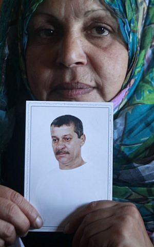 Fatima Nashabat, the wife of Mohammed Nashabat, poses with his picture at her home in the Bureij Refugee Camp, central Gaza Strip, on Monday (photo credit: AP/Hatem Moussa)