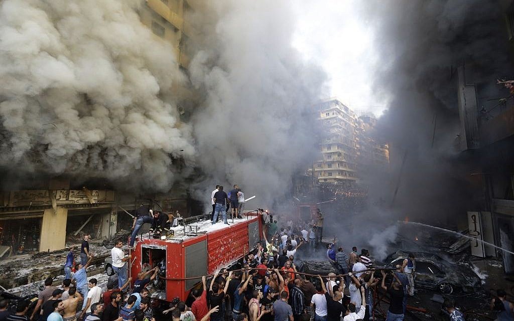 Lebanese citizens and Hezbollah supporters gather at the scene of a car bomb explosion in southern Beirut, Lebanon, Thursday Aug. 15, 2013. (Photo credit: AP/Hussein Malla)